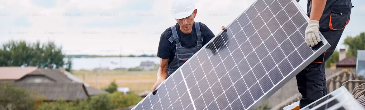 workers preforming a solar panel installation on a roof